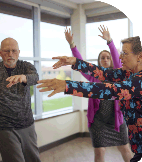 People doing exercises with an instructor in a QiGong class